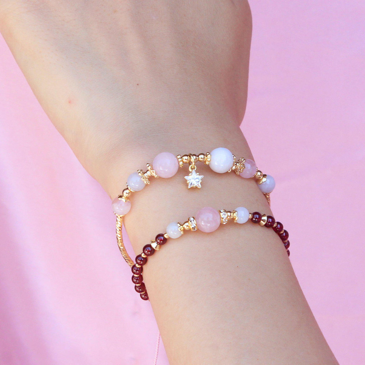 Two Bracelets with red, pink, and white stones and star charm